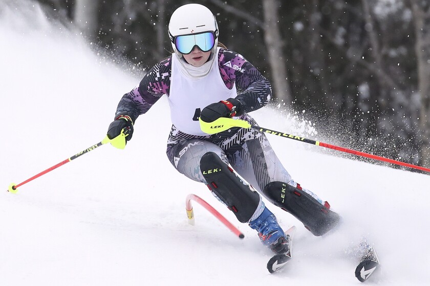 Girl skis around a gate