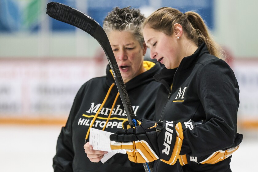 Women hockey coaches work with team