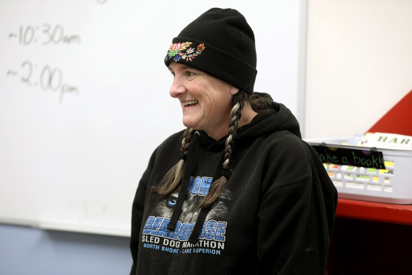 A woman smiling while attending an indoor event.