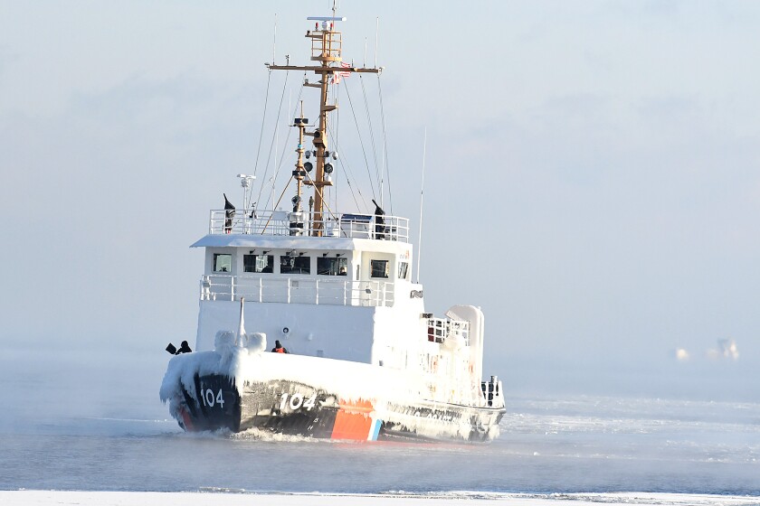 Crew members of the Biscayne Bay toss ice overboard on Lake Superior Crew members of the Biscayne Bay toss ice overboard on Lake Superior