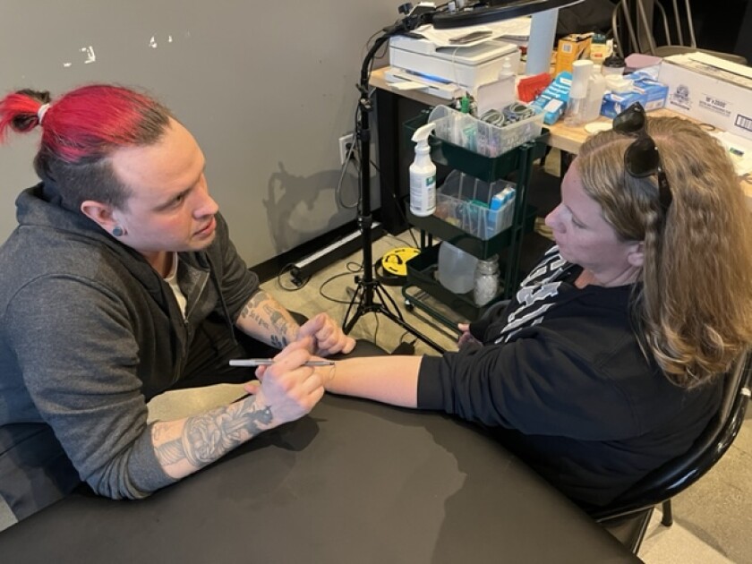 Tattooist Luke Austin talking through the tatoo design process with Julie Dahl at Thesis Beer Project during his March Residency.jpg