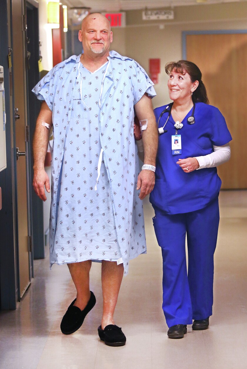 Already up and walking after his accident, Mark Anderson gets help from Terri Schwanangel, a registered nurse at Essentia Health-St. Mary's Medical Center in Duluth on Tuesday morning. Bob King / rking@duluthnews.com