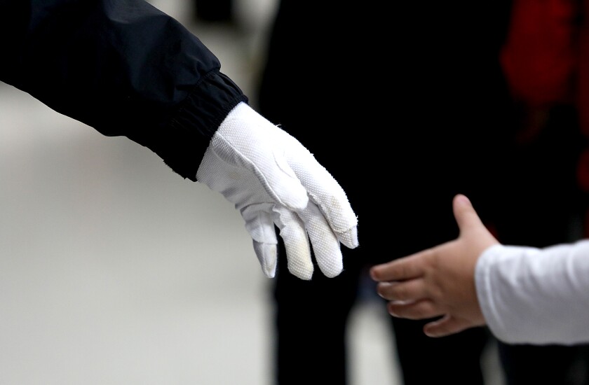 Vietnam veteran Jim White, left, reaches out to shake hands with a student at Great Lakes Elementary School