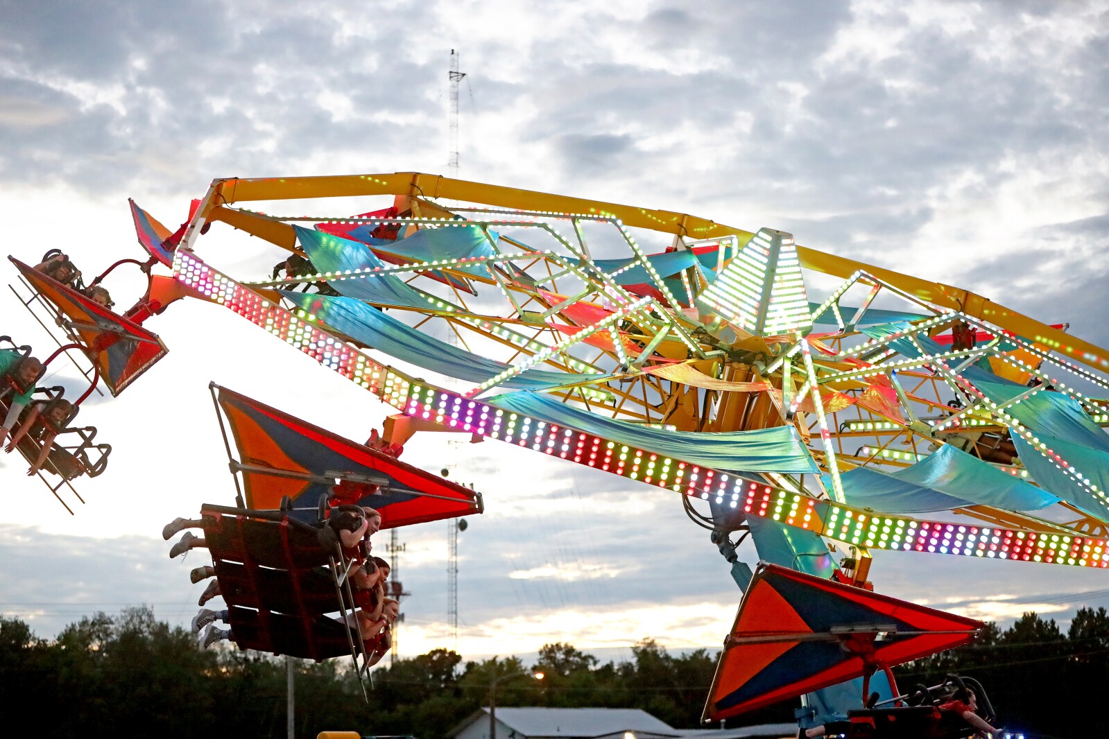 The fair midway ride Soarin' spins people around.
