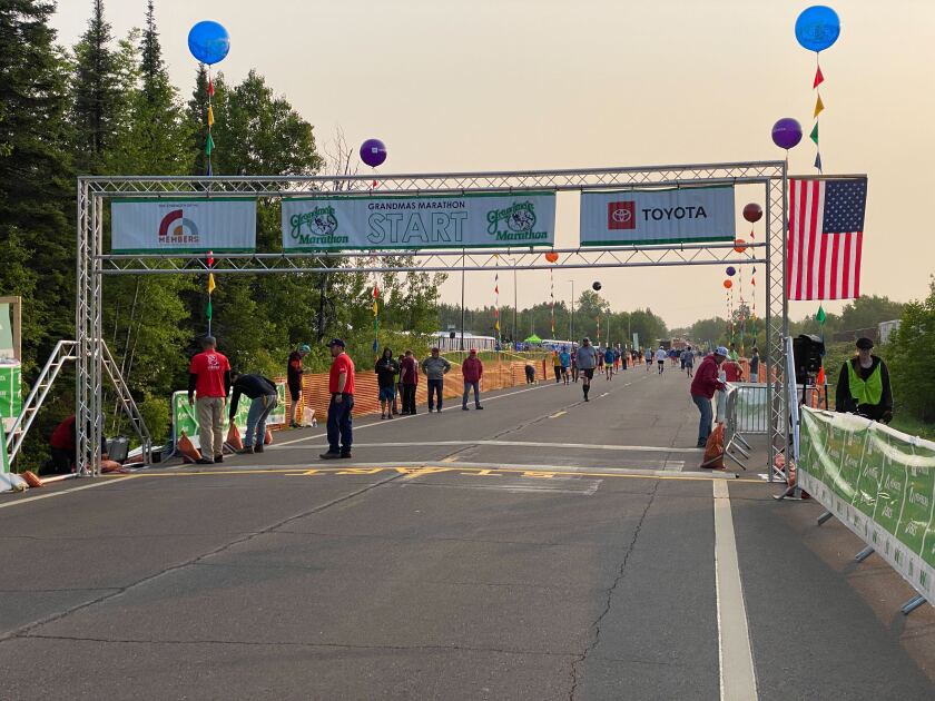 People mill around starting line on highway