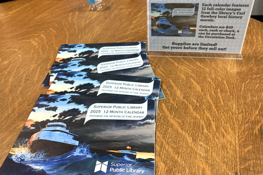 A pile of calendars displayed on a table.