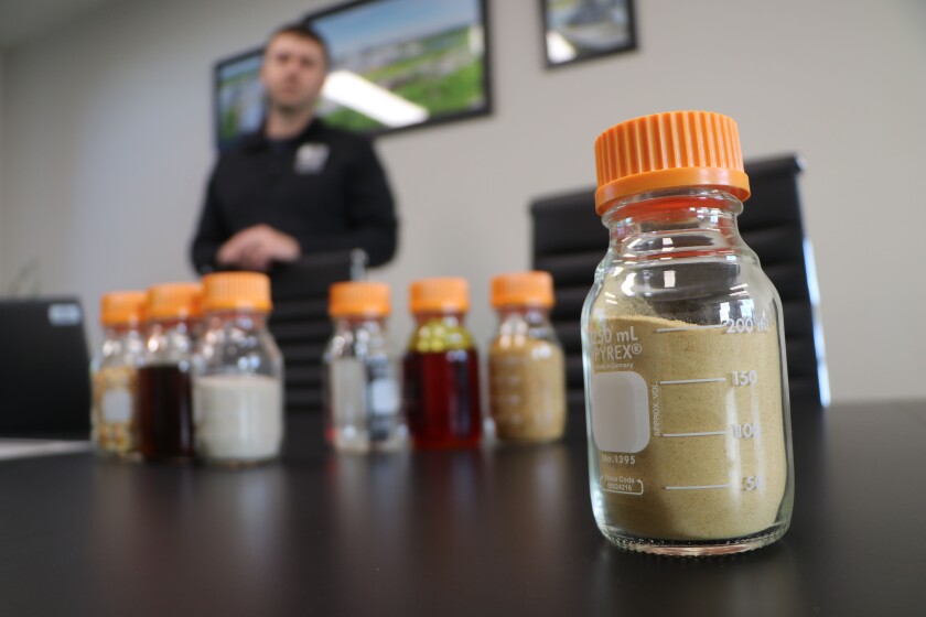 A jar of ultra-high protein feed product is at right, flanked by traditional products from ethanol plants.