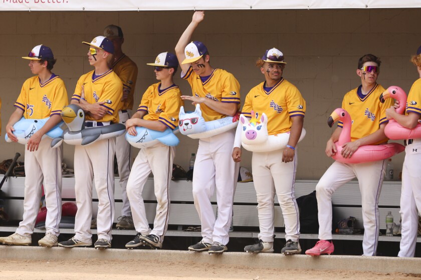 High school baseball players play on outdoor field on sunny day