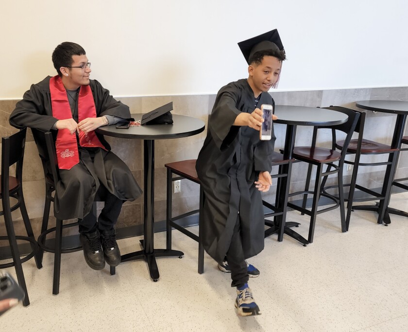 A graduate shows a fellow grad the picture he took for her prior to the graduation ceremony at the Learning Center on Thursday, May 26, 2022.