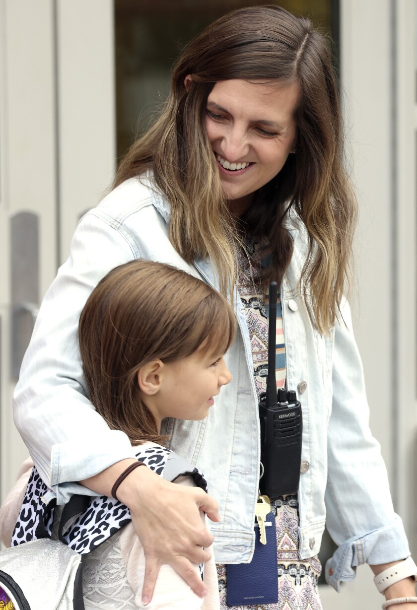 Woman hugs a child.
