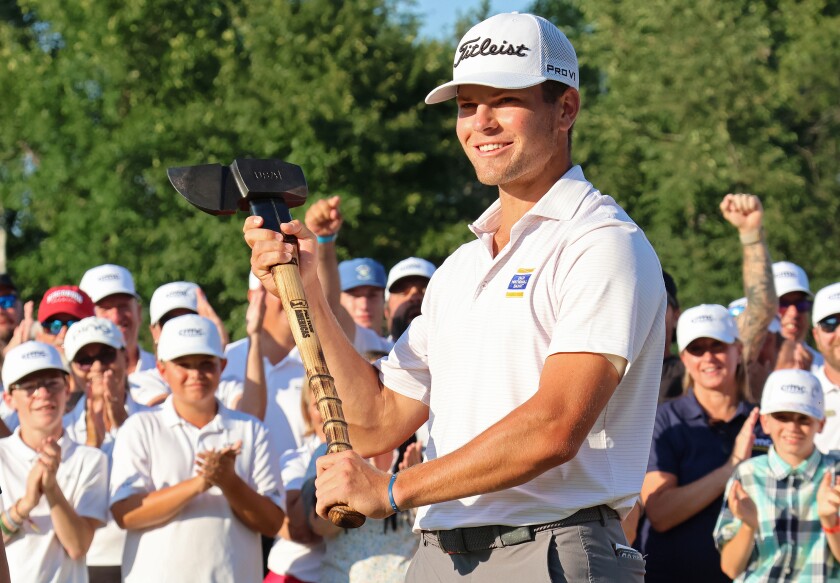 Golfer Michael Brennan holds up the Paul Bunyan Axe Trophy he won as the crowd cheers on Sunday, Aug. 31, 2025, at the close of the PGA Tour Americas CRMC Championship presented by Northern Pacific Center at Cragun's Legacy Courses.