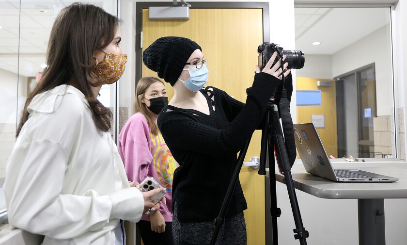 Cassie Aiken, left, and Tatum Williams, center, watch Xalia Raabel tweak the camera