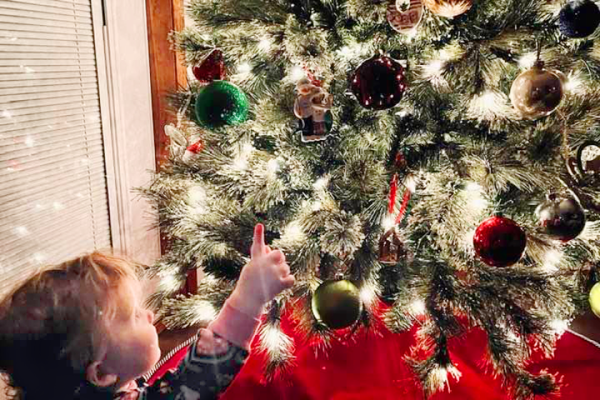 kid by Christmas tree