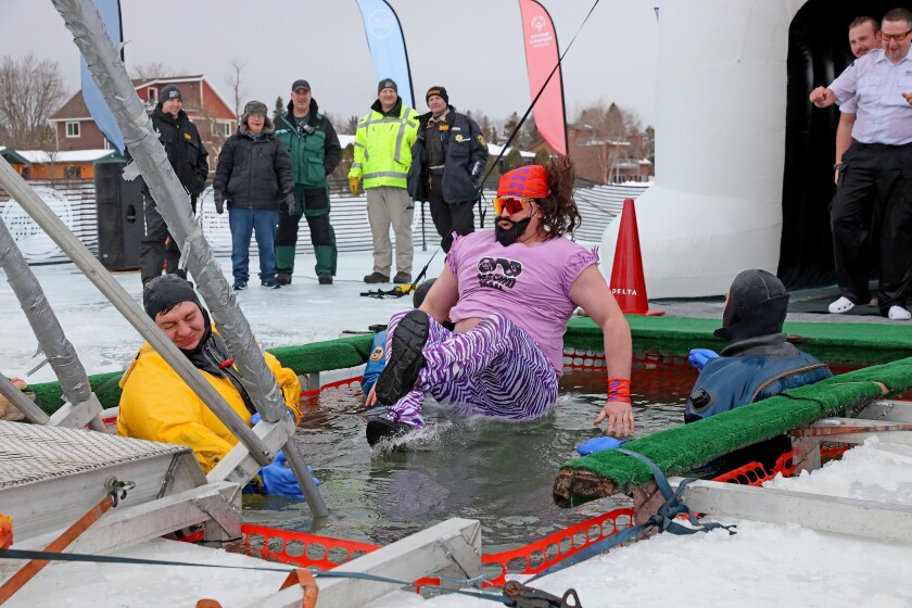 People jump into the water during the Polar Plunge event on Pelican Lake.