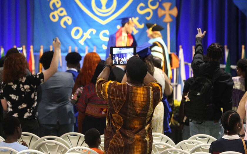 Man uses tablet to record memories of college graduation