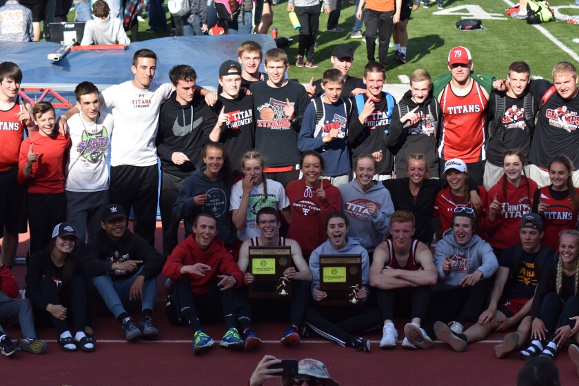 The Dickinson Trinity track teams pose with their Southwest Region Championship trophy on Saturday, May 19 at the Biesiot Activities Center. (Shelby Reardon / The Dickinson Press)