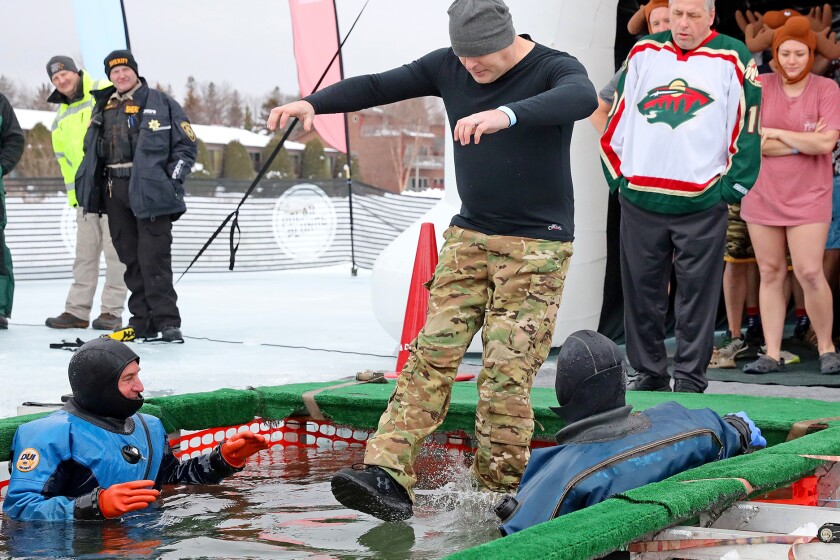 People jump into the water during the Polar Plunge event on Pelican Lake.