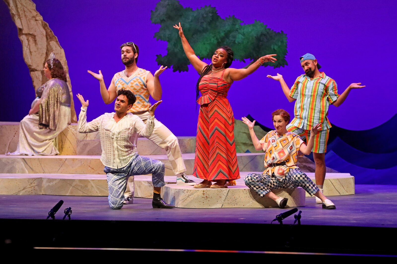 Actors perform on stage.