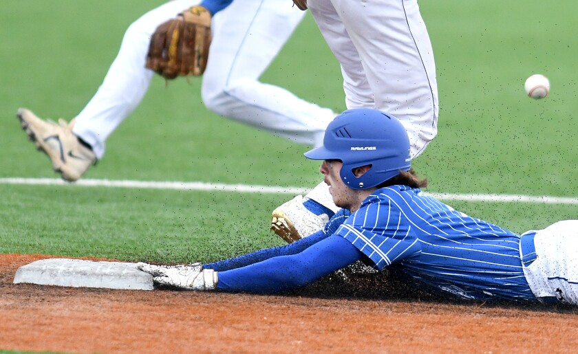 South Ridge’s T. Lisic (7) kicks up turf beads as he slides safely into second for a stolen base