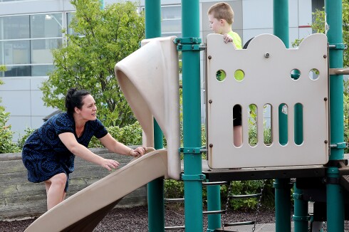 Kid watches mom climb slide.