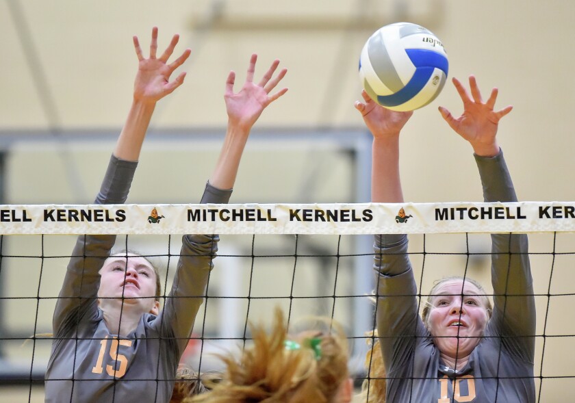 Mitchell's Carly Haring (15) and Mitchell's Mackenzie Miller (10) go up for a block on a Pierre hit during District 3AA action on Tuesday night in the Mitchell High School gym. Mitchell lost the match 3-1. (Matt Gade/Republic)