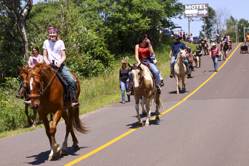 People wearing red white and blue patriotic themed clothing participating in outdoor parade