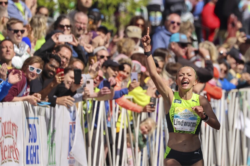 Athletes running and celebrating at the finish line area of Grandma's Marathon