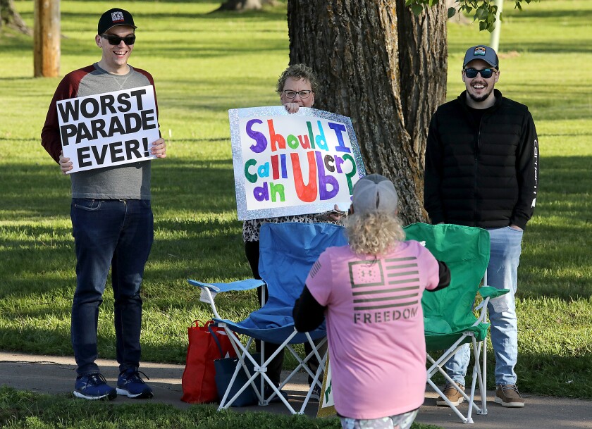 Nick Hayes, left, Theresa Peteren, center, and Isaac Fordahl cheer on runners along London Road