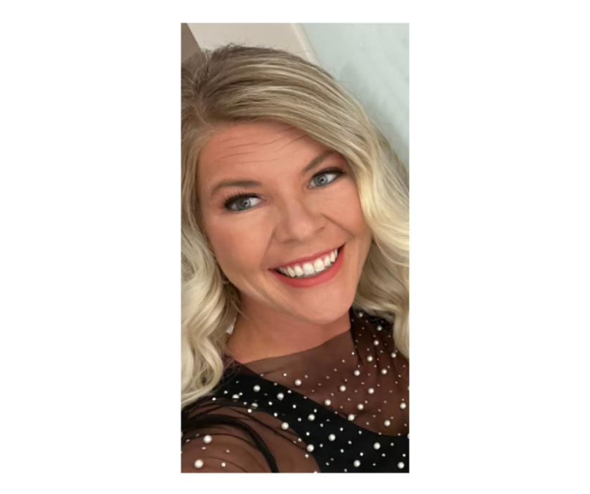 A woman with blond, curled hair smiles in a selfie. Her makeup is done and she wears a mesh shirt decorated with pearls.