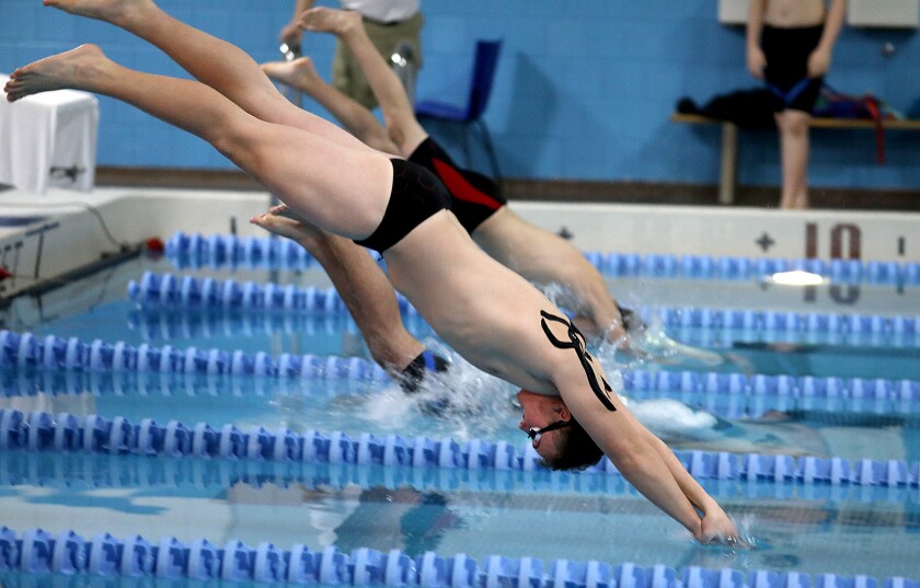 Male swimmers diving into the water.