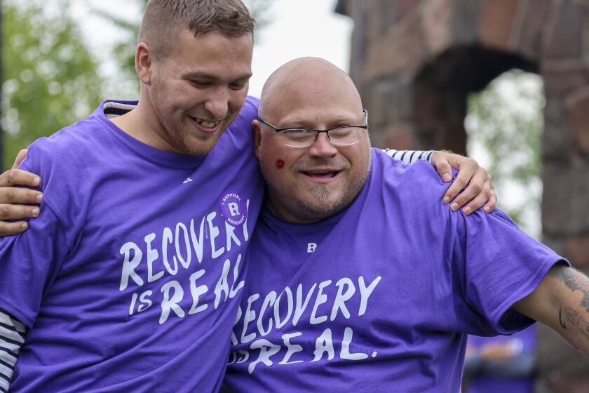 People in purple shirts celebrate recovery in outdoor park