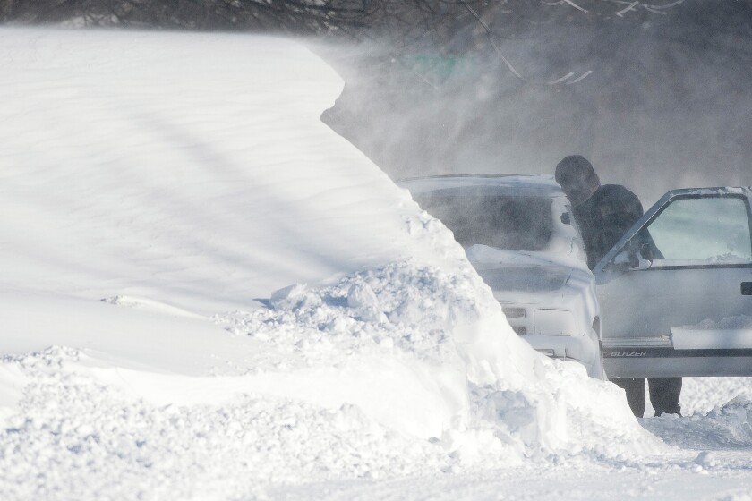 A snowdrift on 22nd Ave. N. in East Grand Forks rises above Kim Schuh's vehicle