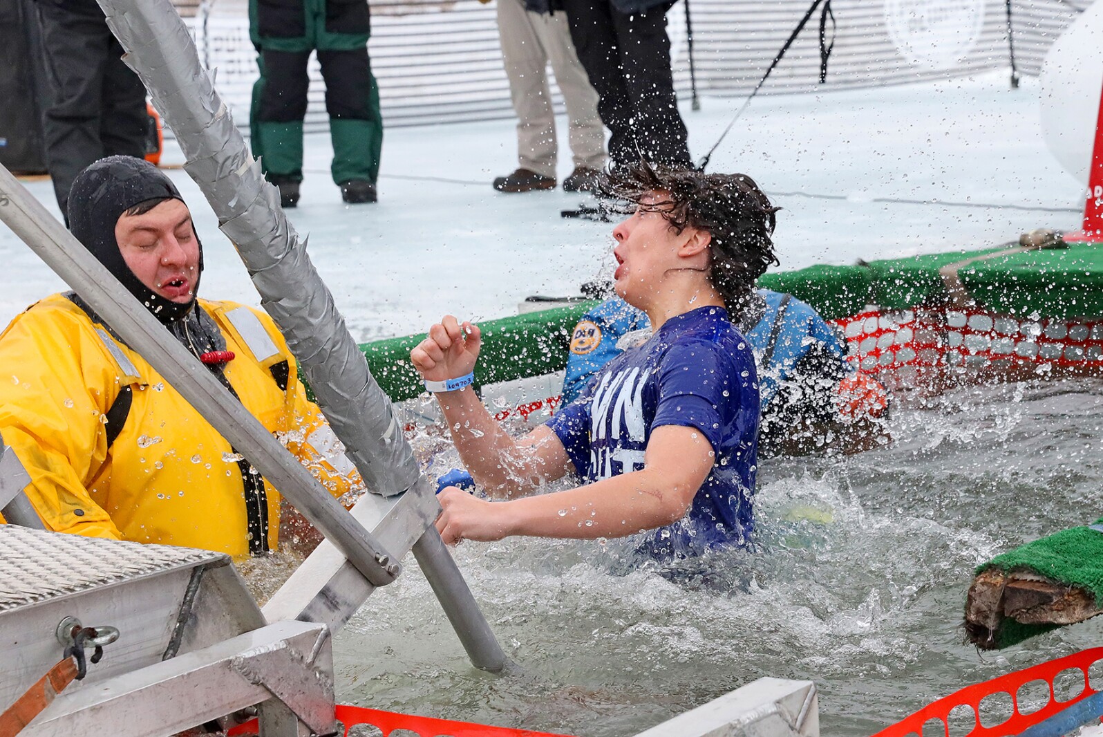 People jump into the water during the Polar Plunge event on Pelican Lake.