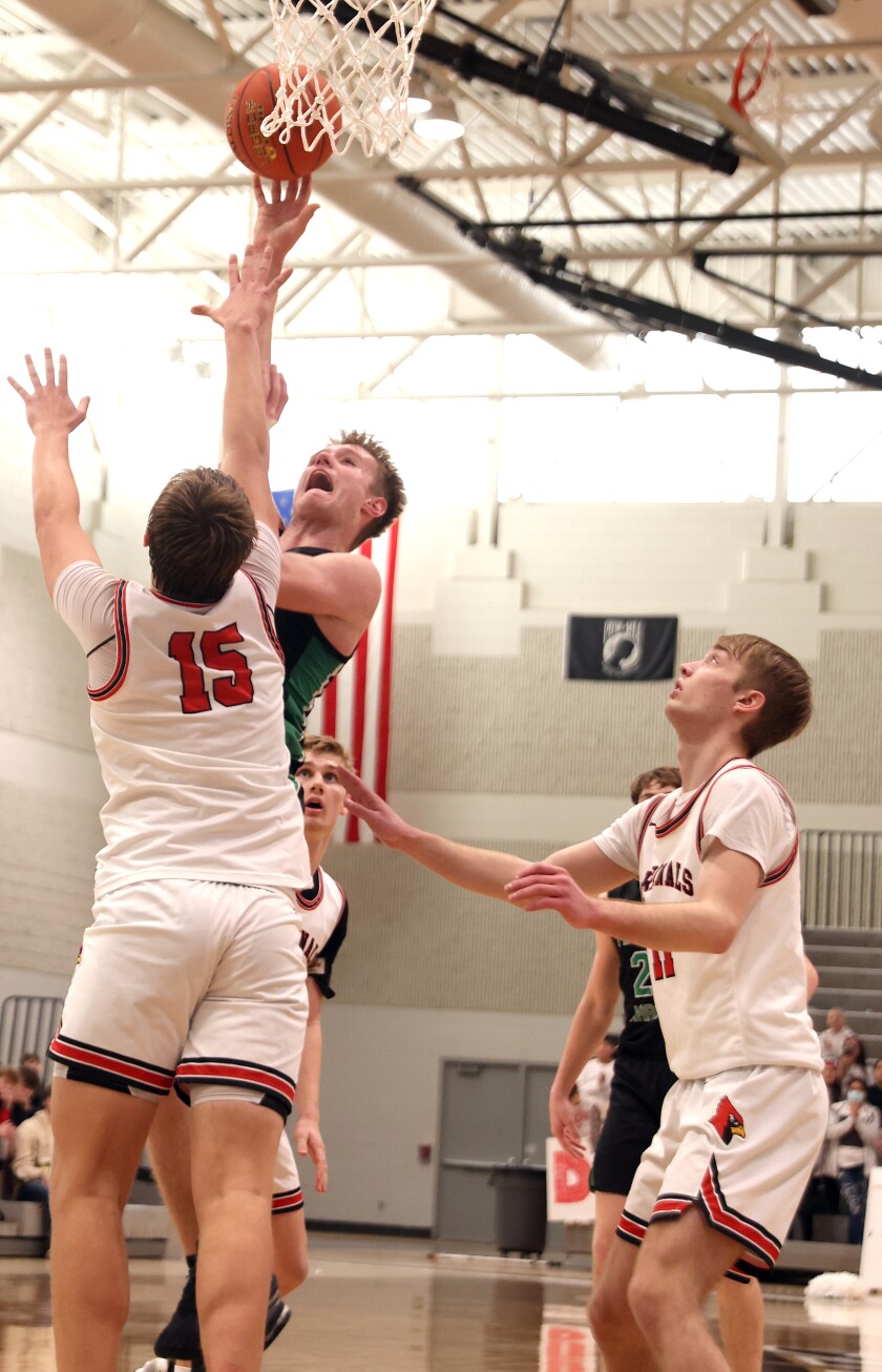 Pipestone Area Arrows Kellen Johnson makes a jump shot against Redwood Valley Cardinals defenders Carson Woodford (15) and Zack Reck during the section 3AA boys basketball tournament Saturday in Marshall.
