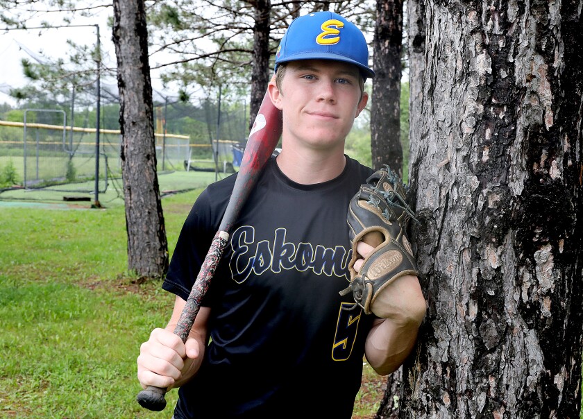 Esko’s Cale Haugen leans on a tree behind the dugout in Esko