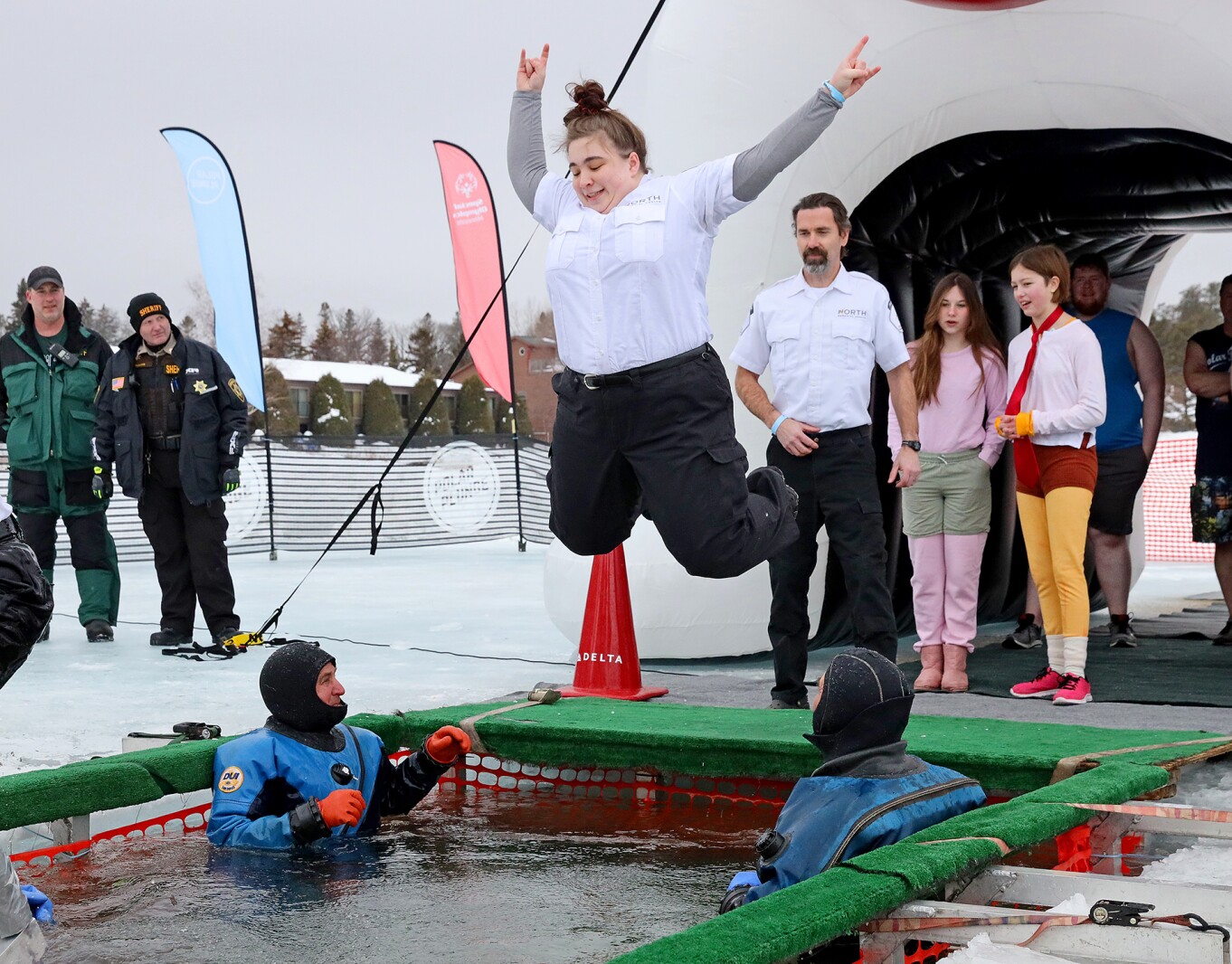 People jump into the water during the Polar Plunge event on Pelican Lake.