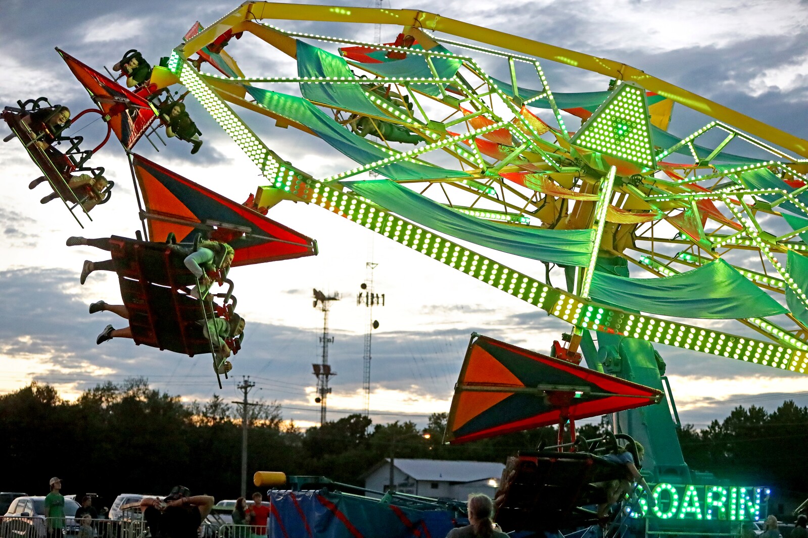 The fair midway ride Soarin' spins people around.