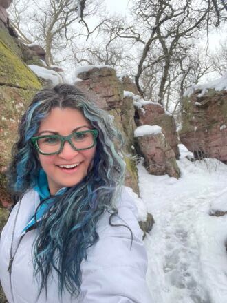 Ashley Cestra smiles for a selfie in a snowy park