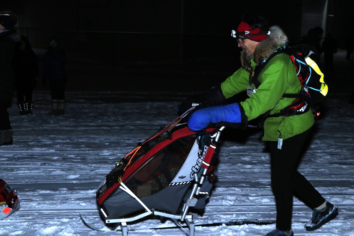 A man kicksleds on a snowy trail.