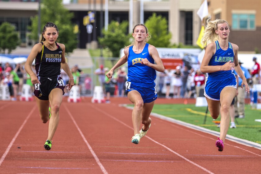 Athletes compete in track and field events at outdoor stadium