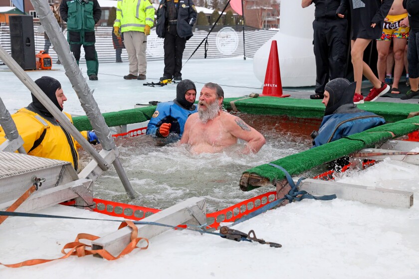 People jump into the water during the Polar Plunge event on Pelican Lake.