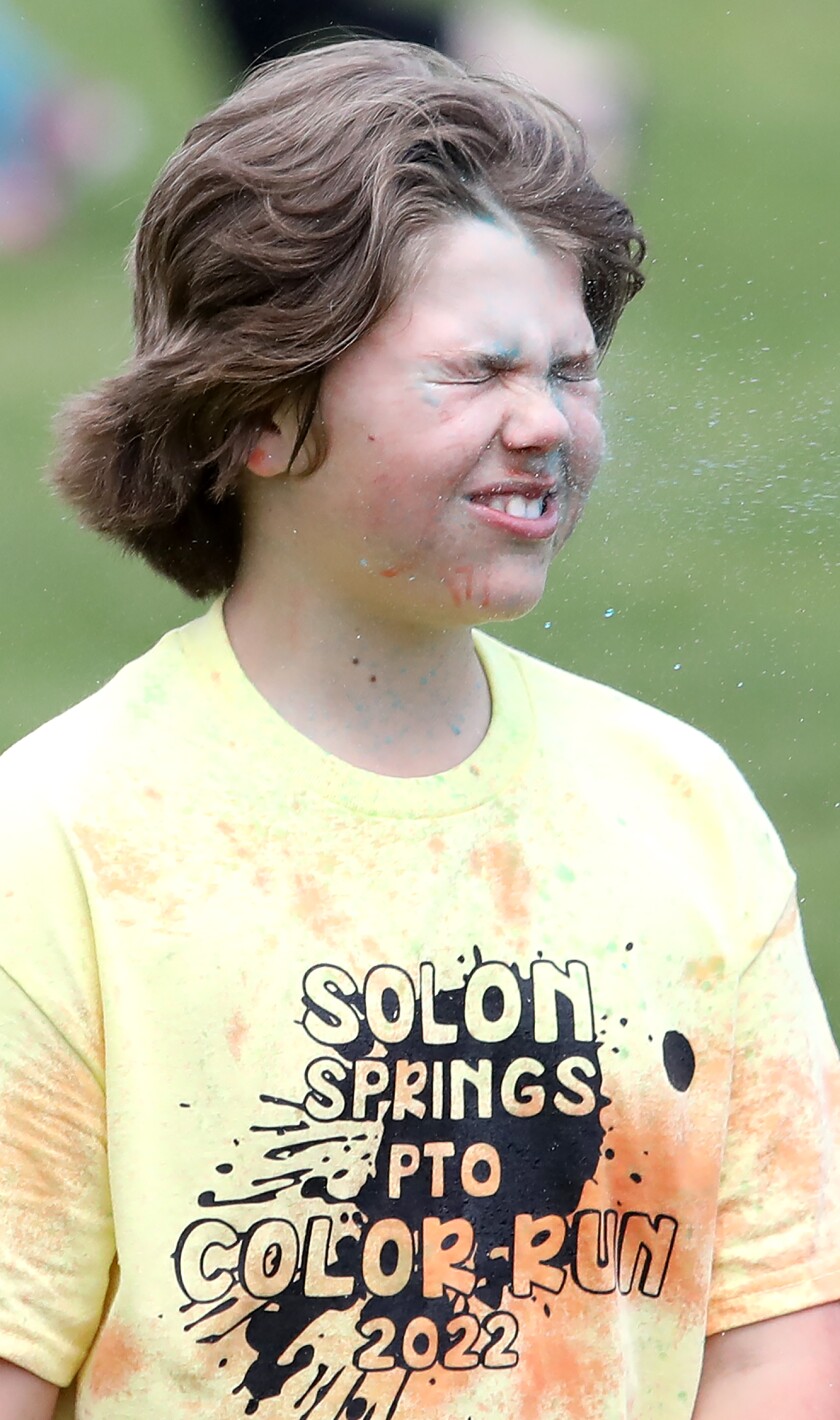 Ezra Ahlberg gets sprayed in the face with blue water