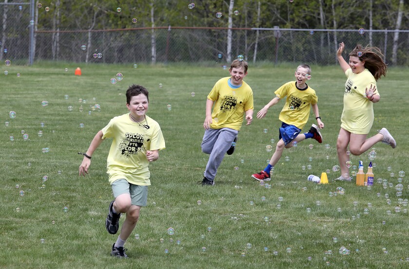 Students, from left, Sol Botner, Landon Brown, Conner Stegmann and Harper Martineau run through bubbles