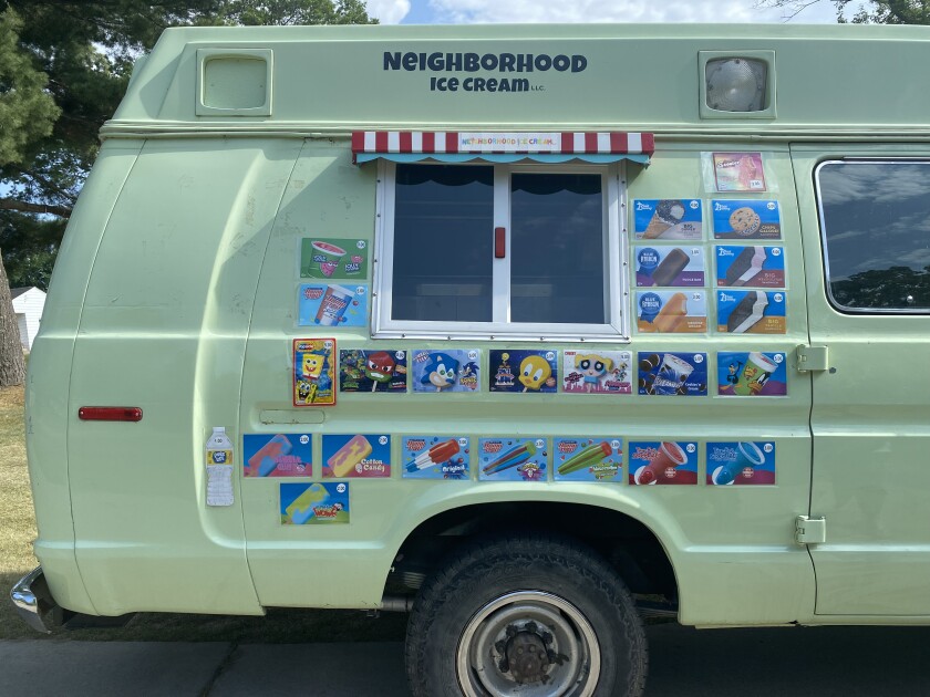 The menu of the ice cream truck on the side of the vehicle.