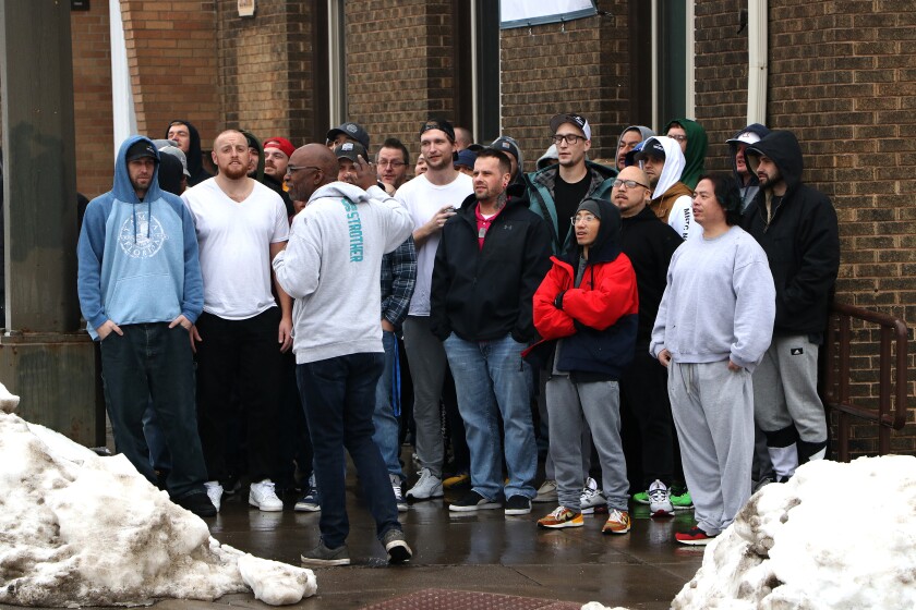 Group of people sing on the sidewalk.