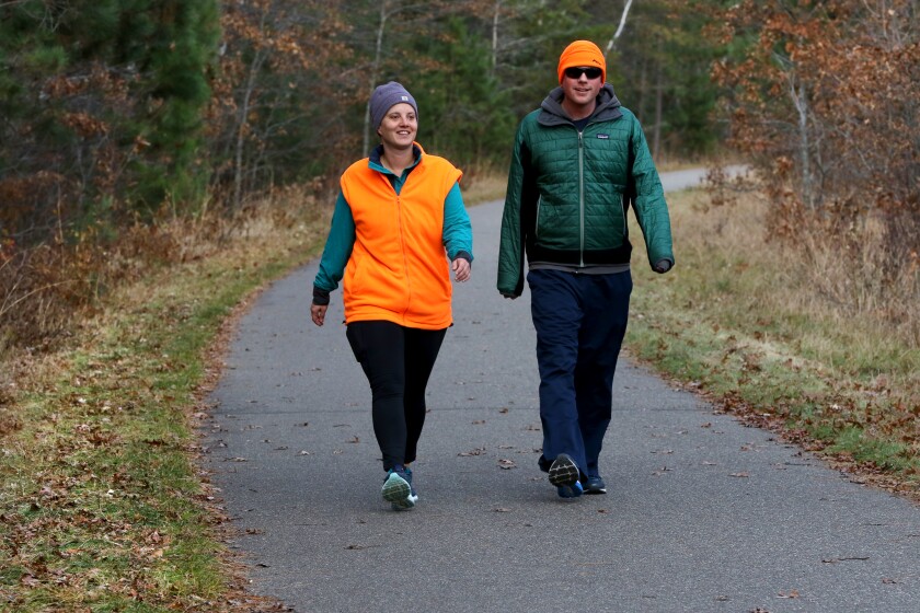 Alli and Justin Isaacson walk along the Paul Bunyan State Trail Saturday, Nov. 3, in Nisswa sporting blaze orange for the start of the firearm hunting season, just to be on the safe side. Hunters and trappers in the field must display blaze orange or blaze pink on their cap or outer clothing above the waist. Hikers and outdoor enthusiasts are also advised to wear blaze orange or pink to be as visible as possible during the hunting season. Kelly Humphrey / Brainerd Dispatch