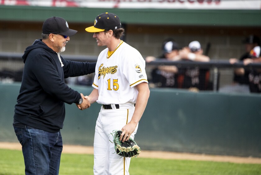 Former Major League Baseball pitcher Eddie Guardado shakes the hand of Willmar Stingers athlete Matt Dreher after throwing the first pitch of the home opener against Eau Claire Express in Willmar on Wednesday, June 1, 2022.