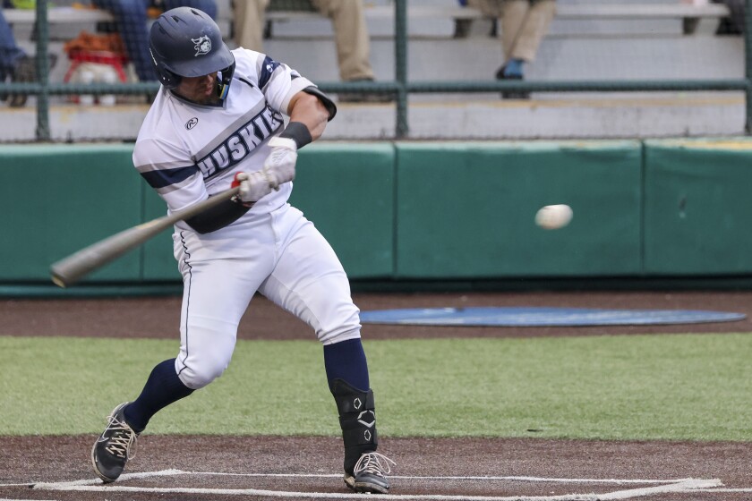 Baseball players in white and blue uniforms playing a game at outdoor stadium