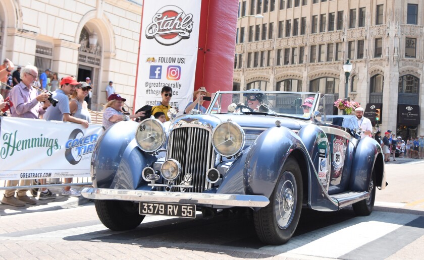 在比赛中观看经典汽车的观众。