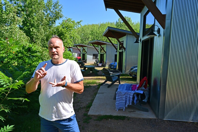 Dan Jurek, the owner of True North Basecamp, speaks of the Crosby complex, Tuesday, August 9, 2022, next to the resort's cabins, which resemble miners' huts that dotted the Cuyuna Range during mining days.